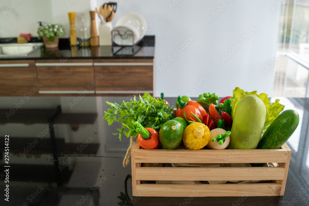 Wooden crates filled with various kinds of fresh vegetables Placed on the counter in the kitchen Wooden crates filled with various kinds of fresh vegetables Placed on the counter in the kitchen