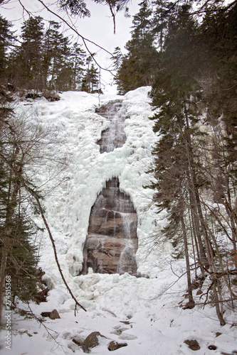 Arethusa Falls Waterfall in the White Mountains of New Hampshire in Winter  Crawford Notch State Park. Frozen and flowing water make the waterfall all the more magical. Ice sculptures formed by nature