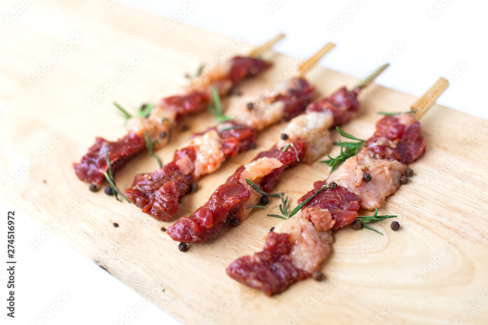 fresh raw beef meat with rosemary and pepper isolated on white