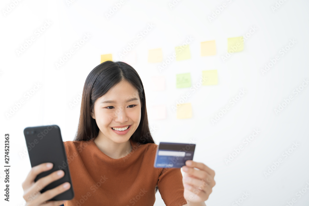 Young Asian woman using smartphone and credit card. Shopping buying online Young Asian woman using smartphone and credit card. Shopping buying online