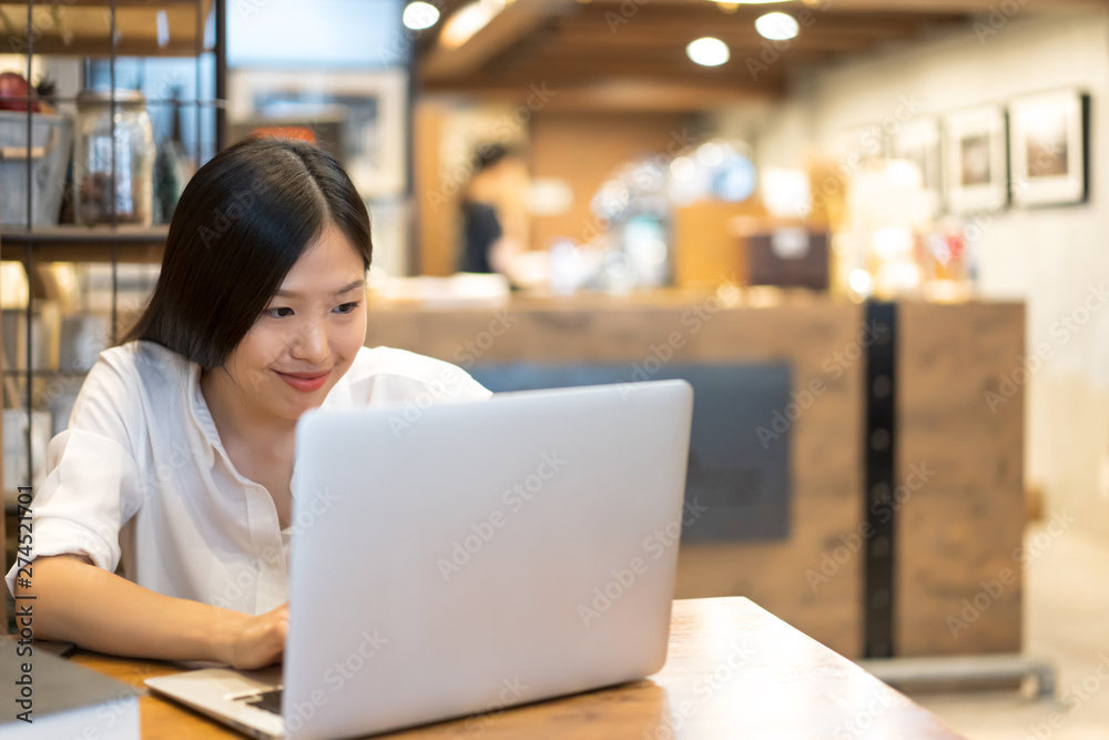 Young Asian woman working with a laptop in the coffee shop cafe office. Young Asian woman working with a laptop in the coffee shop cafe office.