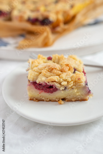 crumble cake in a baking form and pieces of the cake on a table