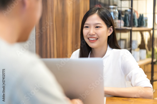Young Asian woman sitting in cafe talking and having a meeting.