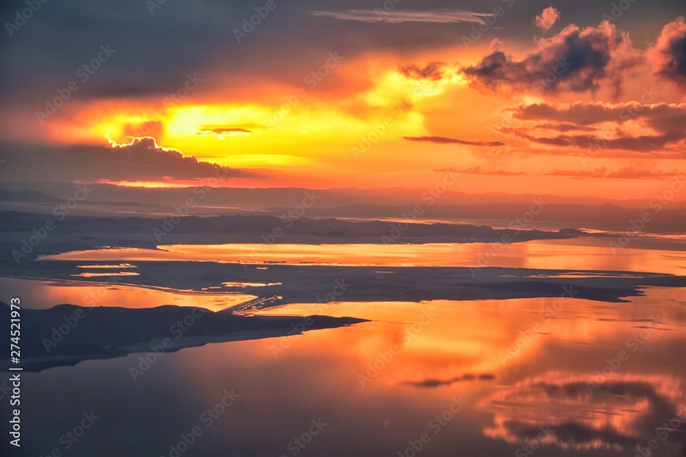 Great Salt Lake Sunset Aerial view from airplane in Wasatch Rocky Mountain Range, sweeping cloudscape and landscape during day time in Spring. In Utah, United States. Great Salt Lake Sunset Aerial view from airplane in Wasatch Rocky Mountain Range, sweeping cloudscape and landscape during day time in Spring. In Utah, United States.
