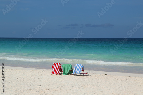 Beach chairs and umbrella on a beautiful Caribbean beach at Harbor Island, Bahamas