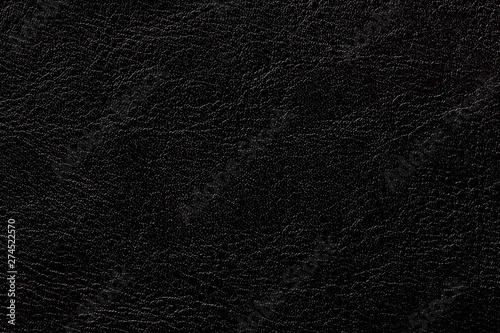 Dark ink leather texture background, closeup. Black cracked backdrop from wrinkle skin