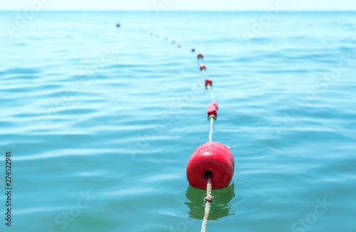 red buoys on the water tied with a rope © Mykola Mazuryk