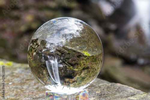 Water cascading down beautiful waterfall, Melincourt, through crystal ball, landscape