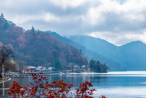 beautiful autumn view of lake Chuzenji with houses, trees and mountains near Nikko, Japan, travel background photo