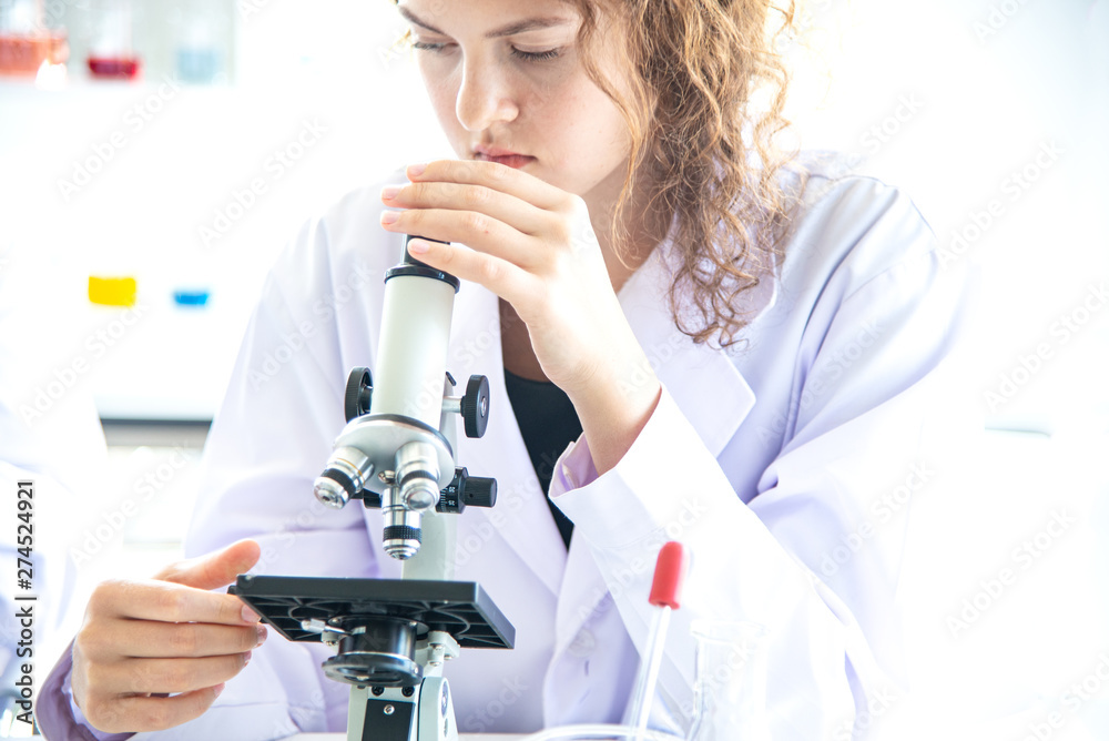 Young woman scientist, researcher, technician, or student conducted research or experiment by using microscope which is scientific equipment in medical, chemistry or biology laboratory Young woman scientist, researcher, technician, or student conducted research or experiment by using microscope which is scientific equipment in medical, chemistry or biology laboratory