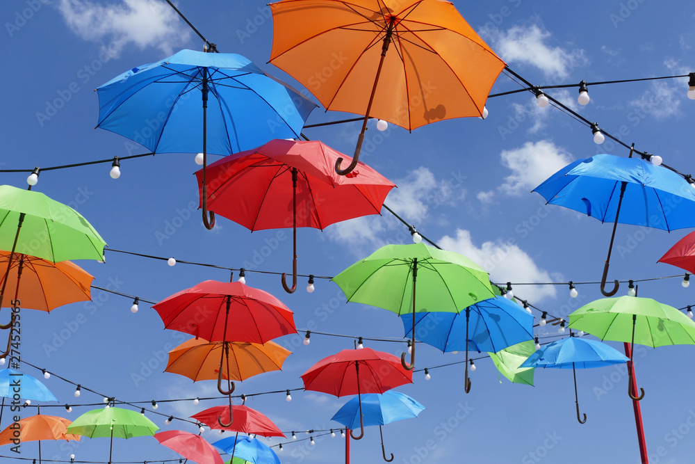 Colorful umbrellas in the sky with white clouds  