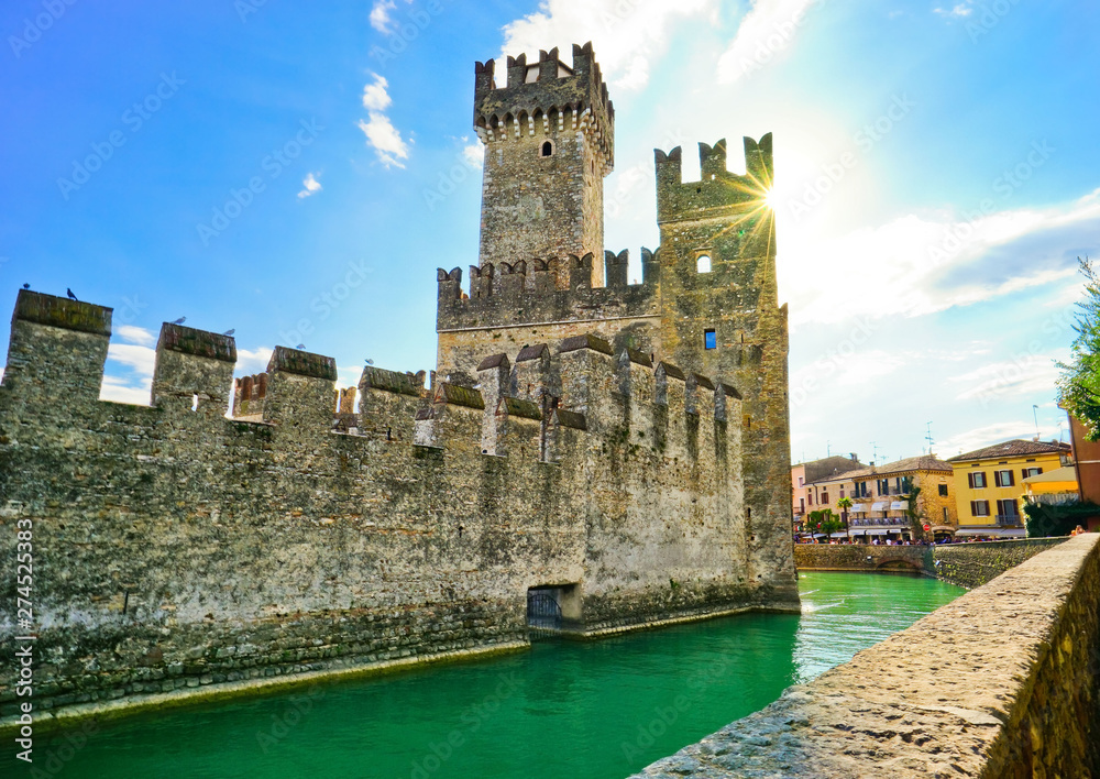 View of Scaligero Castle in Sirmione at the lakeside of Lake Garda in summer. Sirmione is a popular holiday location in northern Italy.