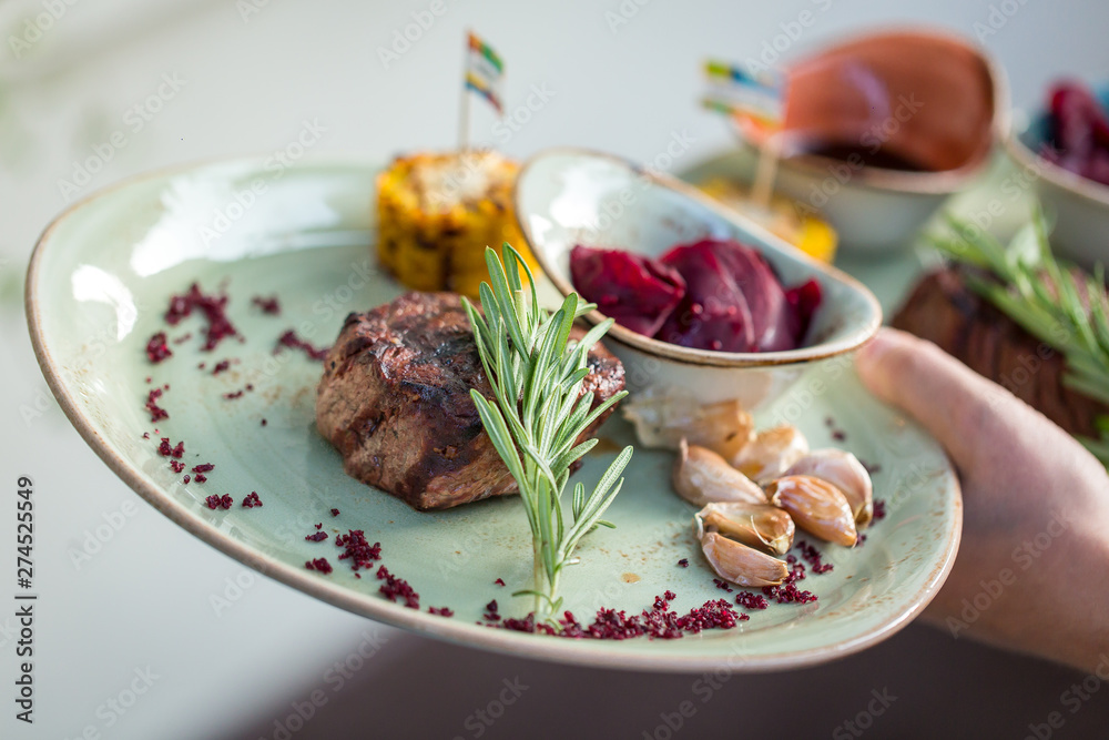 grilled sliced steak and rosemary on plate. serving dishes in the restaurant grilled sliced steak and rosemary on plate. serving dishes in the restaurant