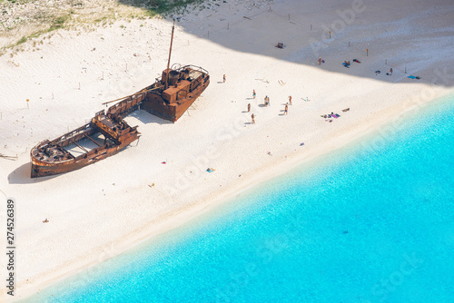 Closeup view to the famous shipwreck beach with people having fun at the turquoise sea, Zakynthos, Ionian islands, Greece