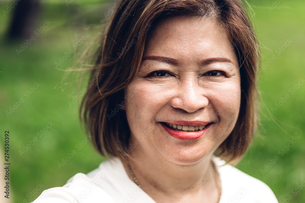 Portrait of happy senior adult elderly asia women smiling and looking at camera in the park.Retirement concept Portrait of happy senior adult elderly asia women smiling and looking at camera in the park.Retirement concept