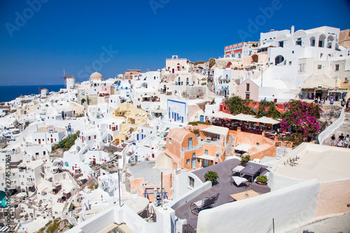 beautiful Oia town on Santorini island, Greece. Traditional white architecture and greek orthodox churches with blue domes over the Caldera, Aegean sea. Scenic travel background