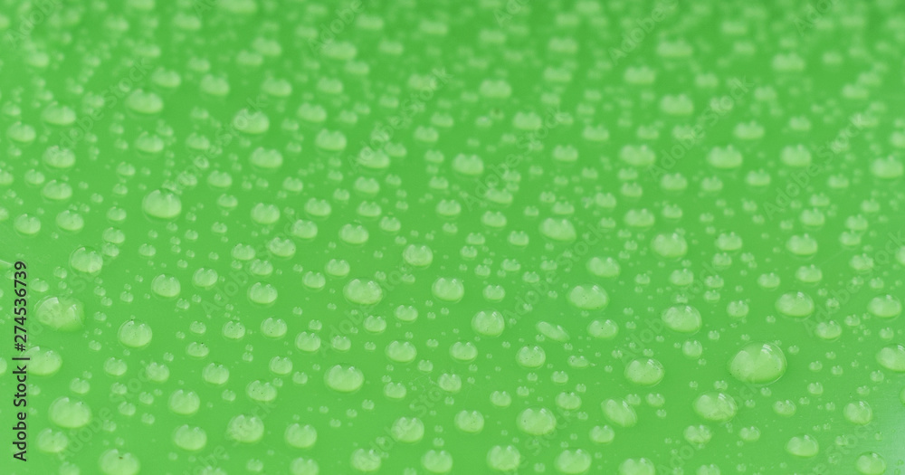 Water drops background. Close up on dew droplets with sharp focus on green surface. Water drops background. Close up on dew droplets with sharp focus on green surface.