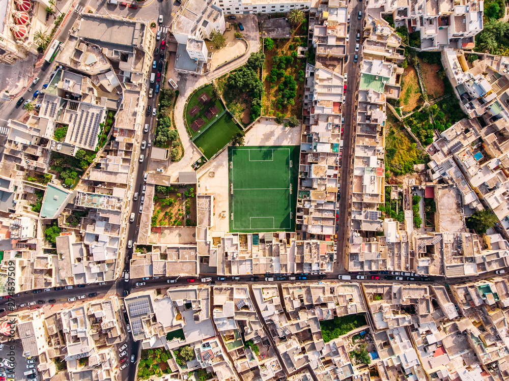 Football field surrounded by stone city. Turkey Malta. Aerial top view