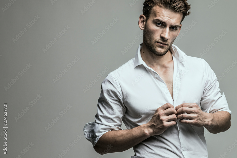 Portrait of young and handsome model in a white shirt. Studio shot. Copy space. Portrait of young and handsome model in a white shirt. Studio shot. Copy space.