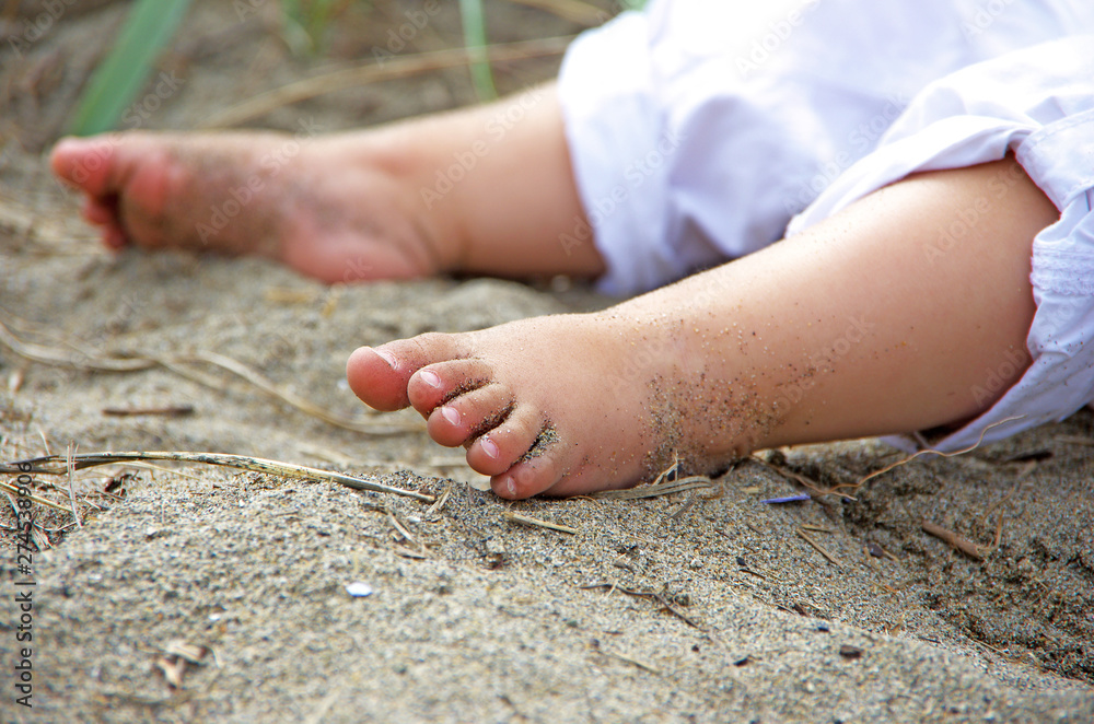 Baby girl wearing white pants, sitting on sandy Kitsilano Beach in  Vancouver BC, Canada, with legs stretched out and bare feet. Stock Photo |  Adobe Stock