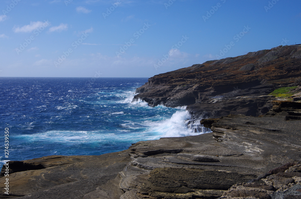 Waves crashing onto cliffs on a sunny day, at the Lanai Lookout in Oahu, Hawaii, USA. Waves crashing onto cliffs on a sunny day, at the Lanai Lookout in Oahu, Hawaii, USA.