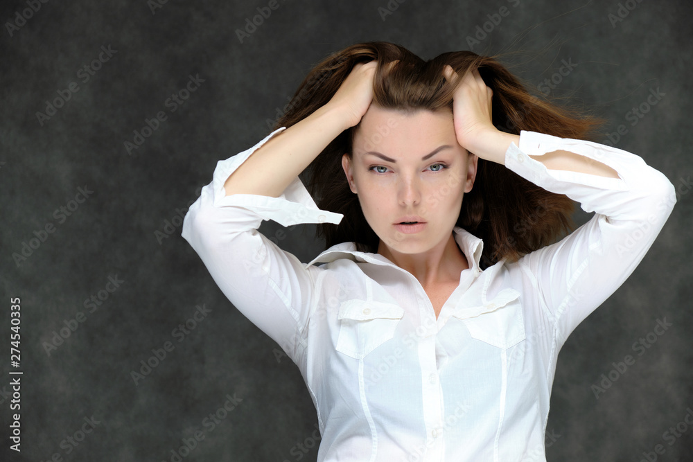 Closeup portrait of pretty girl, brunette woman 30 years old on a light gray background in a white shirt with dark hair and excellent skin. She shows emotions, smiles, wonders. Closeup portrait of pretty girl, brunette woman 30 years old on a light gray background in a white shirt with dark hair and excellent skin. She shows emotions, smiles, wonders.