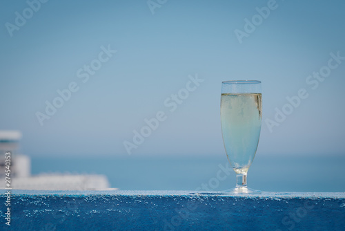 The glass of white crystal and sparkling wine against the wonderful ocean view.
