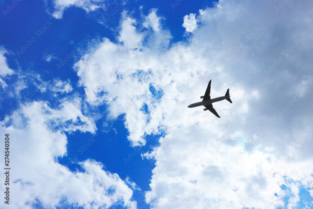 Airplane against a cloud, flying through blue skies and sunshine. Airplane against a cloud, flying through blue skies and sunshine.