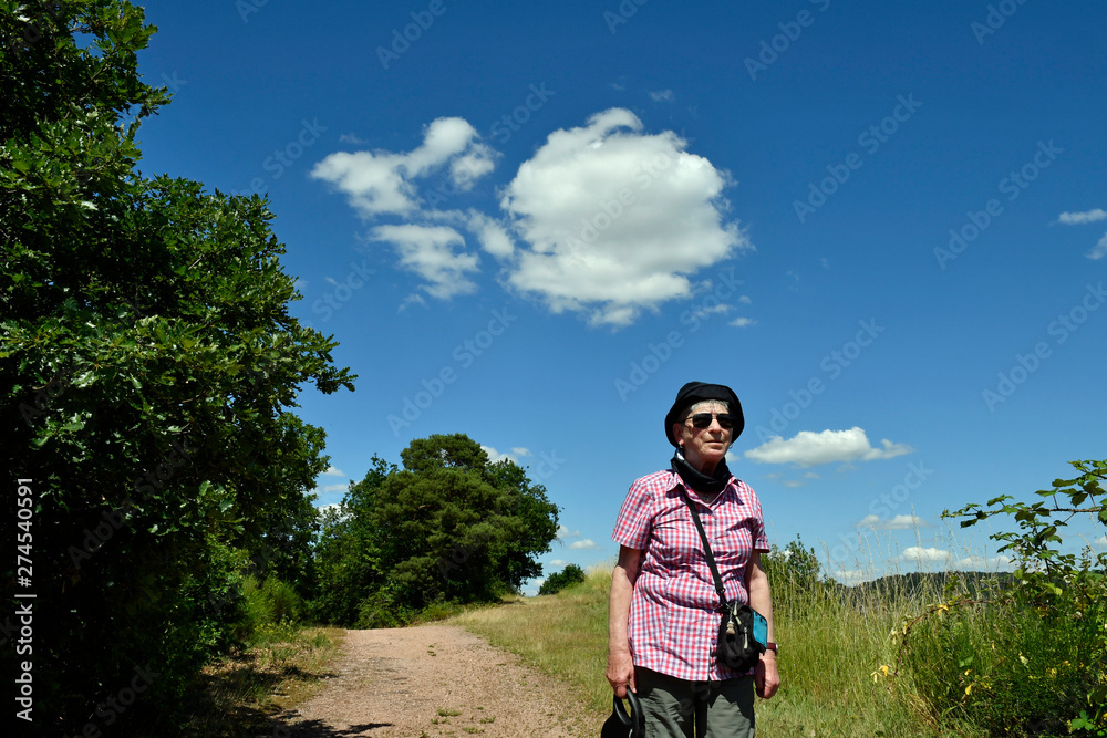 seniorin wandert in einer sommerlandschaft