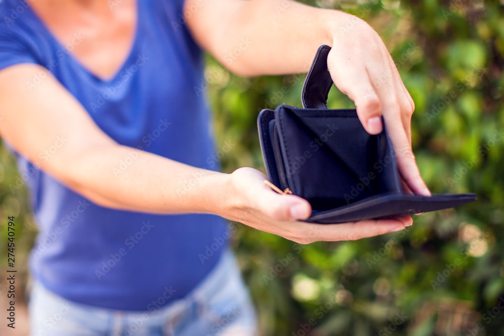 Woman holds an empty wallet in hands. Finance problem concept