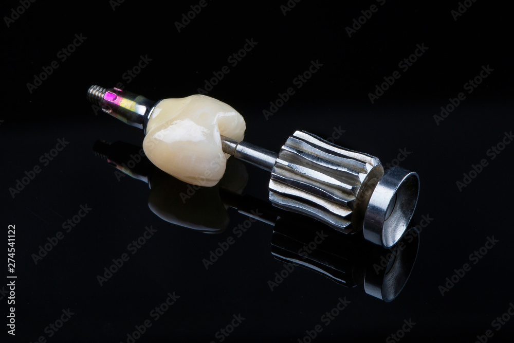 high-quality ceramic dental crown on black glass for patient installation high-quality ceramic dental crown on black glass for patient installation