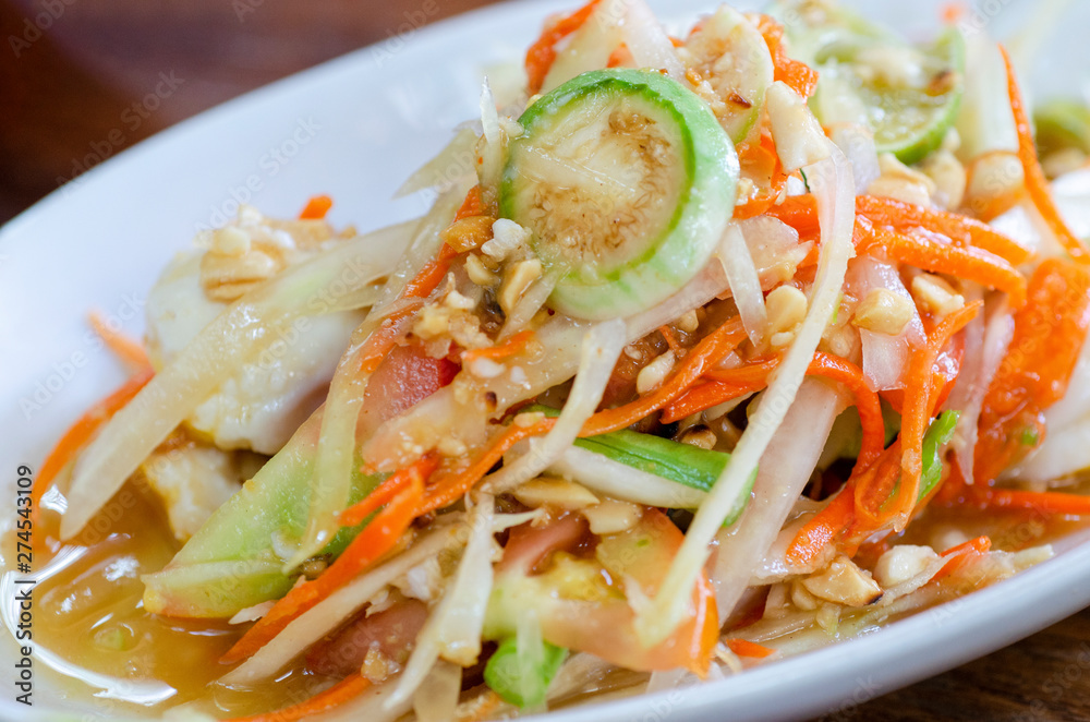 Thai food, papaya salad in a white dish with a blurred background Thai food, papaya salad in a white dish with a blurred background