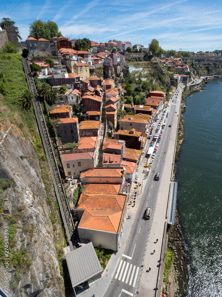 Porto, Portugal, may 2019: View over Porto old town with colorful buildings and red roofs. Promenadein Cais de Ribeira along Duoro river on a sunny day.