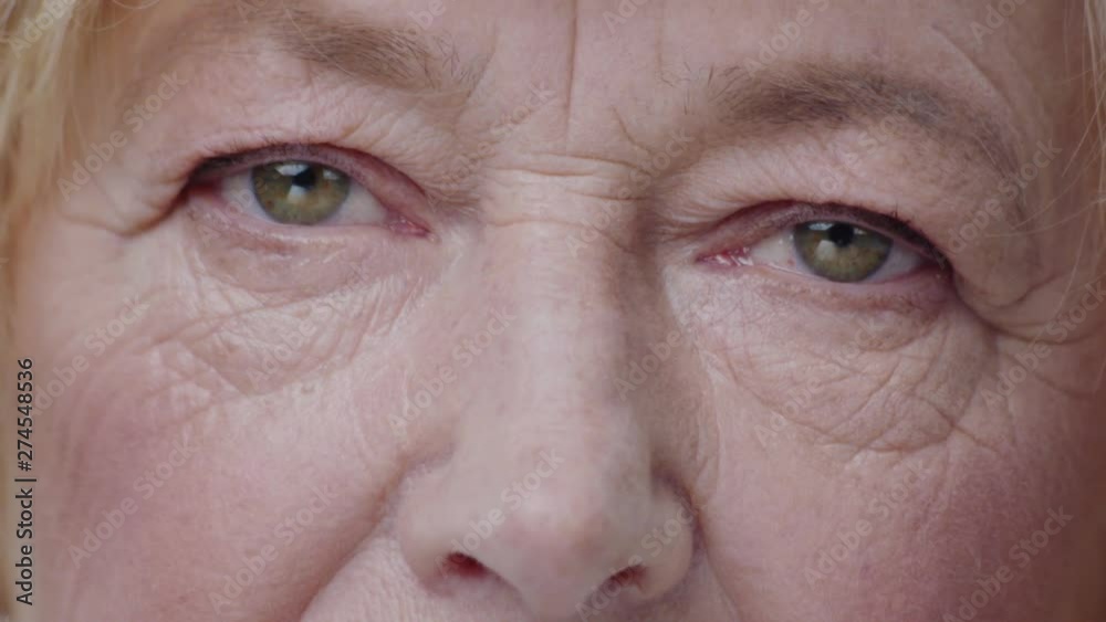 Close-up macro view of beautiful mature woman green eyes opening and looking straight on a wrinkled face. Close-up macro view of beautiful mature woman green eyes opening and looking straight on a wrinkled face.
