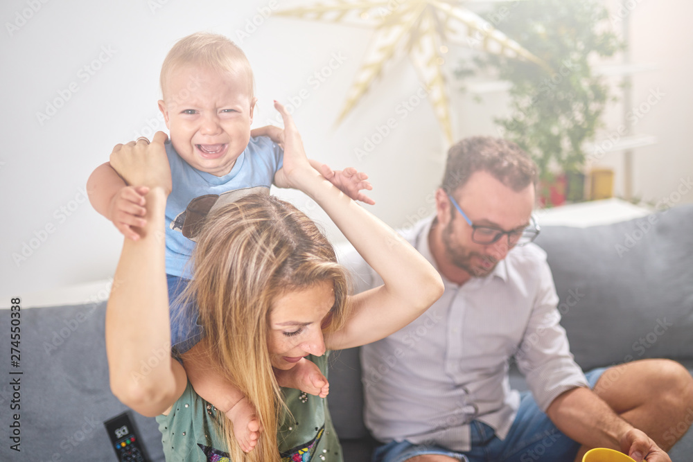 Angry baby crying and parents who are trying to cheer him up. Angry baby crying and parents who are trying to cheer him up.