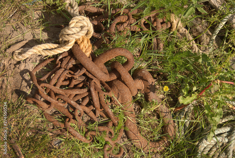 rusty fishermans chain & rope in grass rusty fishermans chain & rope in grass