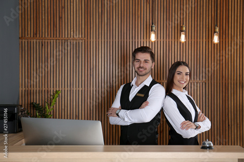 Smiling receptionists at desk in modern lobby