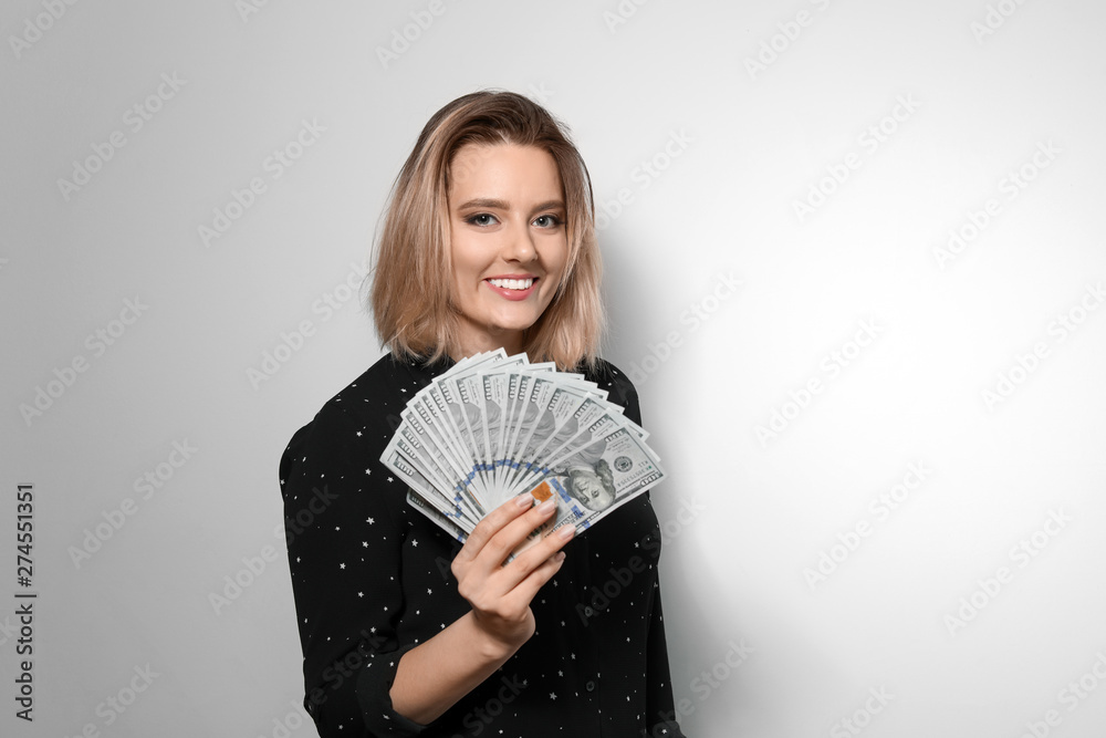 Portrait of young woman with money fan on light background Portrait of young woman with money fan on light background