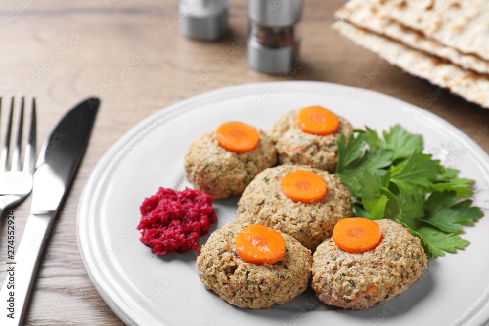 Plate of traditional Passover (Pesach) gefilte fish on wooden table, closeup