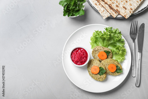 Flat lay composition with plate of traditional Passover (Pesach) gefilte fish on light background. Space for text photo