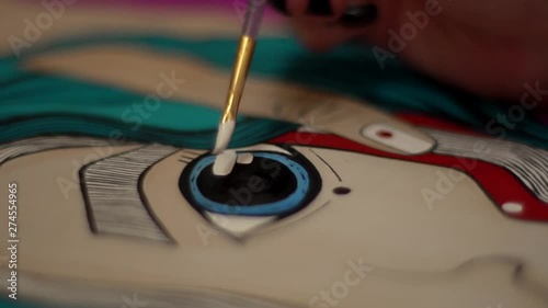 Artist at work.  Paints a picture. Big blue eye.