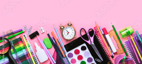 Back to school background with space for text, notebooks, pens, pencils, other stationery on pink modern background, education concept, flat lay, top view