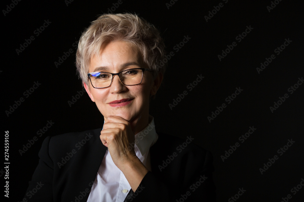 stylish elderly woman in glasses and black jacket on a black background stylish elderly woman in glasses and black jacket on a black background