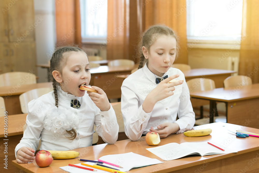 Foto de Teenage girls have lunch between school lessons. Two ...