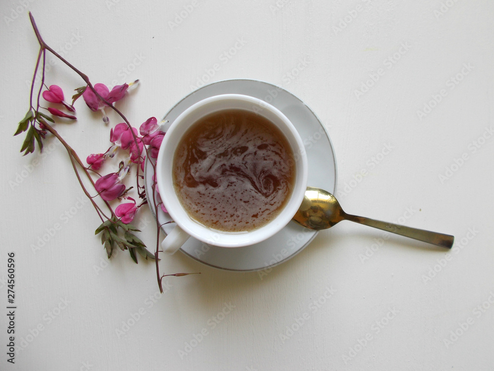 Tea in a white Cup, with pink flowers Tea in a white Cup, with pink flowers