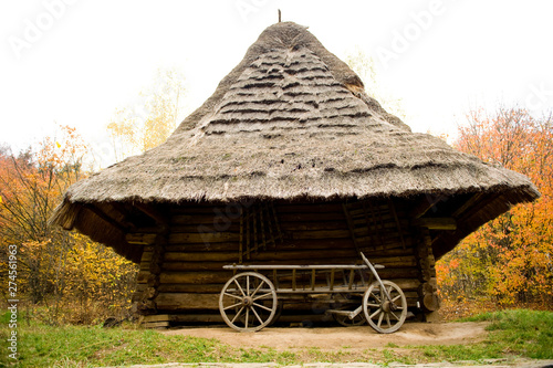 Old wooden house with thatched roof. Traditional Ukrainian architecture