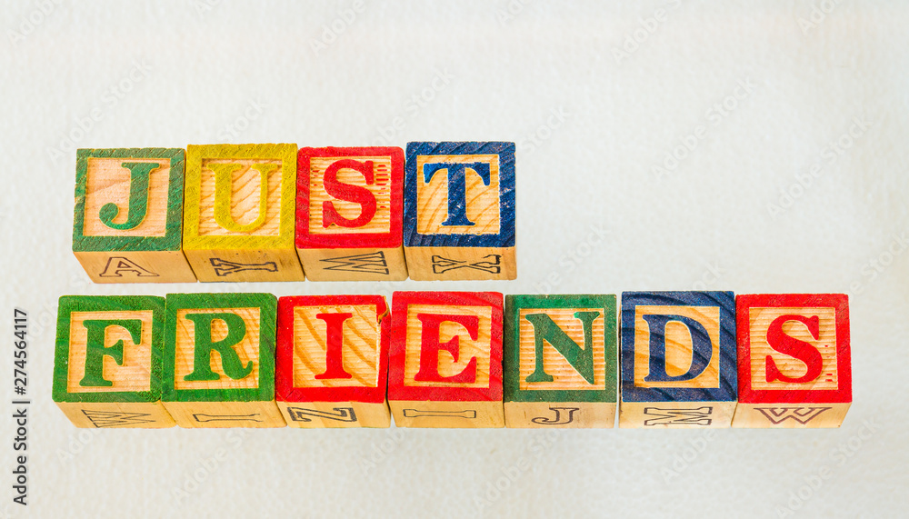 The term just friends visually displayed on a clear background using colorful wooden blocks image in landscape format with copy space