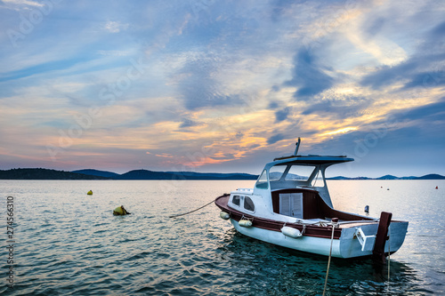 Sunset at the croatian coast with a nice view on a fisher boat. © Christian