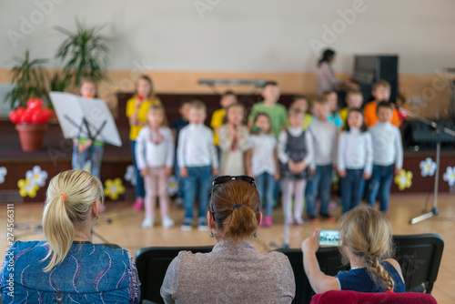 Performance by talented children. Children on stage perform in front of parents. image of blur kid 's show on stage at school , for background usage. Blurry