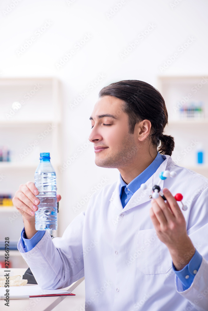 Fototapeta premium Young male chemist experimenting in lab